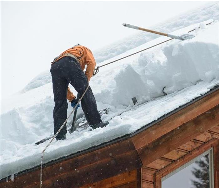  Professional removing Snow from the Roof.
